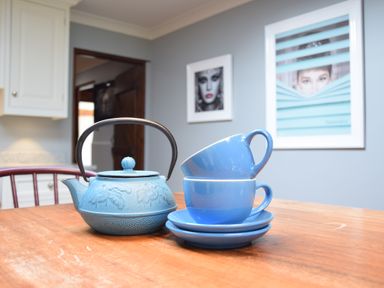 A blue teapot and two blue cups on saucers on a wooden table in a kitchen at Moat Barn Hasketon Near Woodbridge
