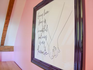 A framed wall art with the text every love story is beautiful but ours is my favorite and a drawing of two hands holding at Moat Barn in Hasketon Near Woodbridge