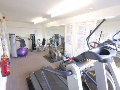 A small gym room with exercise machines weights a treadmill and an exercise ball at The Gallery Blythburgh near Southwold