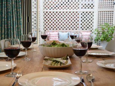 A dining table set with wine glasses plate cutlery salad bowl and asparagus at Tamarisk Aldeburgh in Aldeburgh
