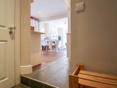 View from a hallway into a dining area with a round table and chairs at Kestrel in Southwold