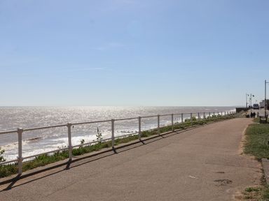 A coastal promenade with metal railing along the sea and a paved walkway at Kestrel in Southwold