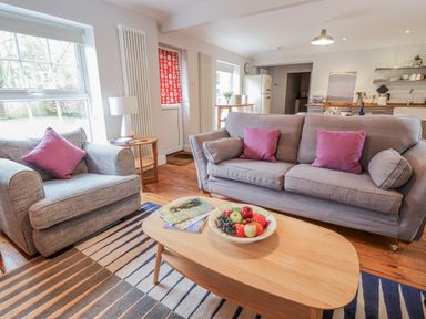 A living room with a sofa and armchair at Fig Cottage, Pettistree Near Woodbridge