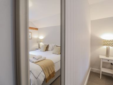 A bedroom with a bed and lamp at Fig Cottage, Pettistree Near Woodbridge