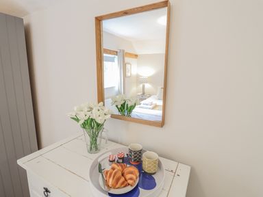 A tray with croissants and cups on a white chest at Fig Cottage, Pettistree