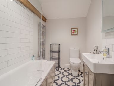 A bathroom with a bathtub, sink, and toilet at Fig Cottage, Pettistree Near Woodbridge