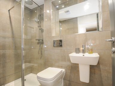 A bathroom with a shower enclosure toilet and sink at Bluebell Retreat in Lostwithiel