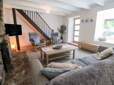 A living room with a sofa, chairs, and coffee table at Candle Croft in Tolgus Mount near Redruth