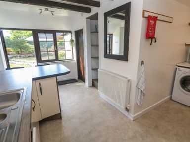 A kitchen with a sink and washing machine at Candle Croft in Tolgus Mount near Redruth