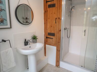 A bathroom with a shower and sink at Candle Croft Tolgus Mount near Redruth