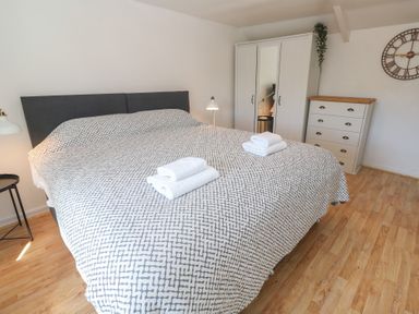 A bedroom with a large bed and wardrobe at Candle Croft in Tolgus Mount near Redruth