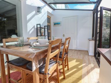 A dining room with a table and chairs at Candle Croft in Tolgus Mount near Redruth