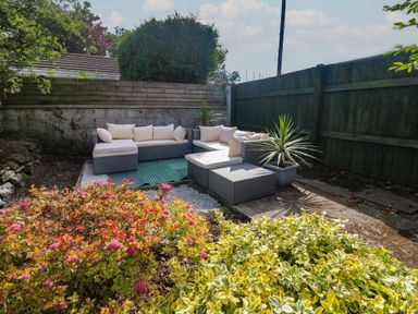 A garden with outdoor seating and flowers at Candle Croft in Tolgus Mount near Redruth