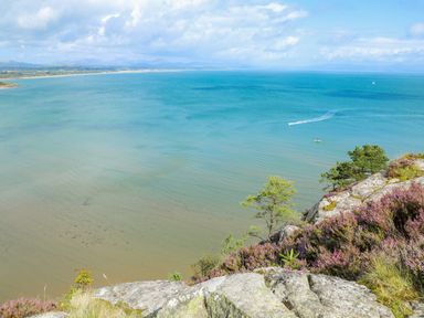 A coastal view with cliffs and vegetation overlooking the sea at Watlands in Mynytho near Abersoch