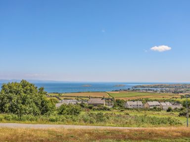 A coastal landscape with fields houses and the sea in the background at Watlands in Mynytho near Abersoch