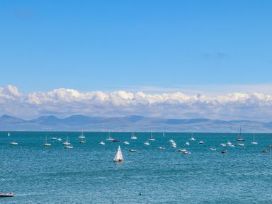 A sea view with many small boats and sailboats with mountains in the background at Watlands in Mynytho near Abersoch