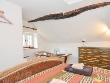 A bedroom with a bed and a bathtub at Rose Cottage Okehampton