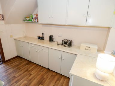 A kitchen counter with a kettle toaster bread box and lamp at Sea Watch House in Roundstone County Galway