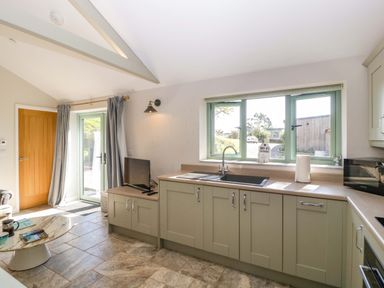 A kitchen with cabinets and a sink at Bottom Lodge in Penhow