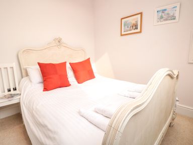 A bedroom with a white bed and orange pillows at The Old Chapel in Dittisham