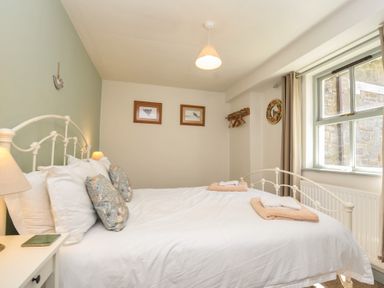 A bedroom with a bed and window at The Mews in Blisland