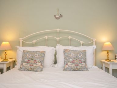 A bedroom with a bed and bedside tables at The Mews in Blisland
