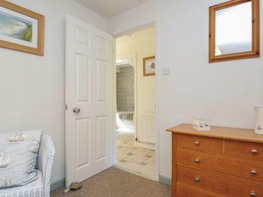 A bathroom with a door leading to another room at The Mews in Blisland