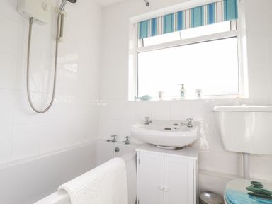A bathroom with a bathtub shower sink and toilet at Smugglers in Liskeard near St Cleer