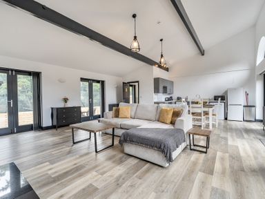 A living room with a sofa and dining area at The Annex in Wimborne Minster