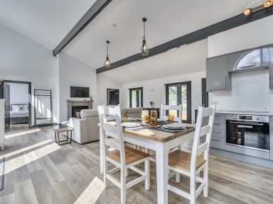 An open plan living and dining area with a dining table and kitchen at The Annex Wimborne Minster