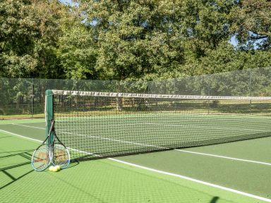 A tennis court with tennis rackets and balls at The Annex Wimborne Minster