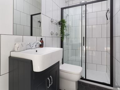 A bathroom with a sink, toilet, and glass shower enclosure at Wansfell at Lipwood House in Windermere