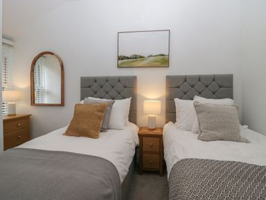 A bedroom with two single beds bedside table and lamp at Rose Cottage in Ambleside