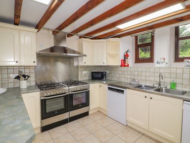 A kitchen with two ovens a microwave dishwasher double sink and cabinets at Old School Muncaster House Ravenglass near Holmrook