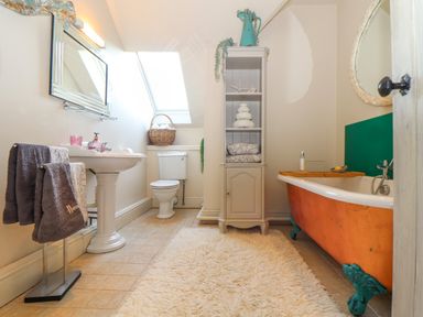 A bathroom with a pedestal sink towels basket toilet cabinet and clawfoot bathtub at Lower Gadles Burnthouse near Falmouth