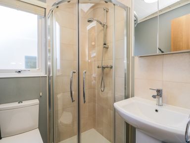 A bathroom with a shower enclosure toilet and sink at Wansfell Lodge in Pony Meadow 36 White Cross Bay near Windermere