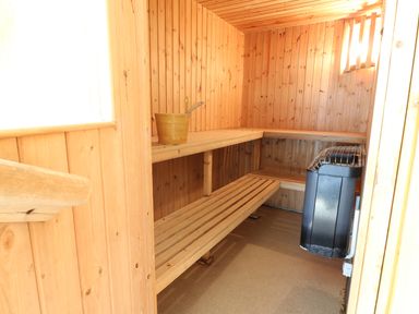 Sauna room with wooden benches bucket and heater at The Coach House in St Florence