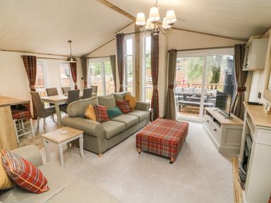 A living room with sofas dining table and chairs and a television at Coniston View 9 Dock Acres near Tewitfield
