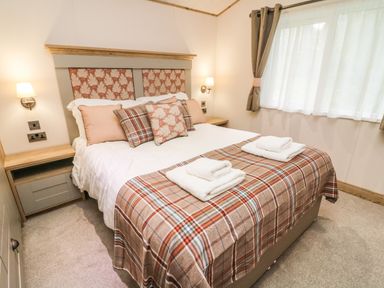 A bedroom with a double bed and bedside tables at Coniston View 9 Dock Acres near Tewitfield