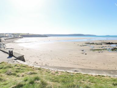 A beach view with houses and a rubbish bin at Ocean House Broad Haven