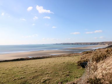A beach scene with sea and cliffs at Ocean House Broad Haven