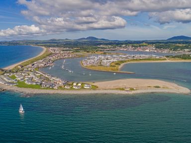 An aerial view of a coastal town with a marina several boats and houses along the shoreline at Fairview Lodge in Pwllheli