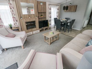 A living room with armchairs sofa coffee table and dining table at Starfish Retreat in Little Haven near Broad Haven
