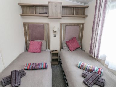 A bedroom with two single beds side by side with towels on them at Starfish Retreat in Little Haven near Broad Haven