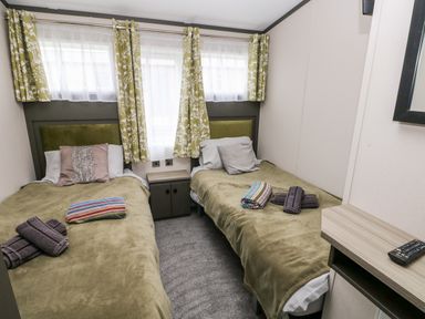 A bedroom with two single beds with towels on each at Ramsey in Broad Haven