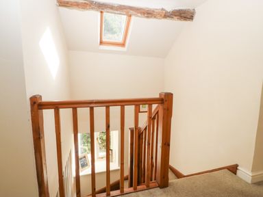 A wooden staircase railing under a skylight window at Tyn Llwyn in Eisingrug near Harlech