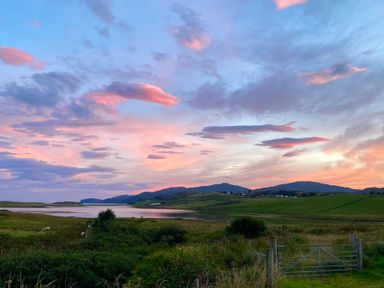 A rural landscape with a lake hills and a metal gate at Shepherds Hut in Dunvegan