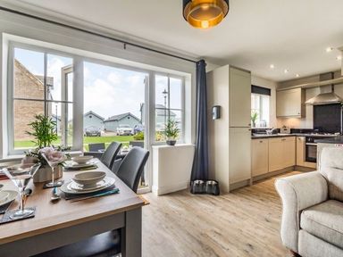 A kitchen and dining area with a wooden table set for meals and a seating area at Lantern House in Filey