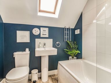 A bathroom with a toilet sink bathtub and a plant at Lantern House in Filey
