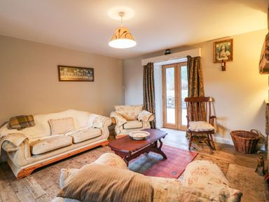 A living room with sofas a wooden rocking chair a coffee table and French doors at Coffey's in Ballymacarbry County Waterford